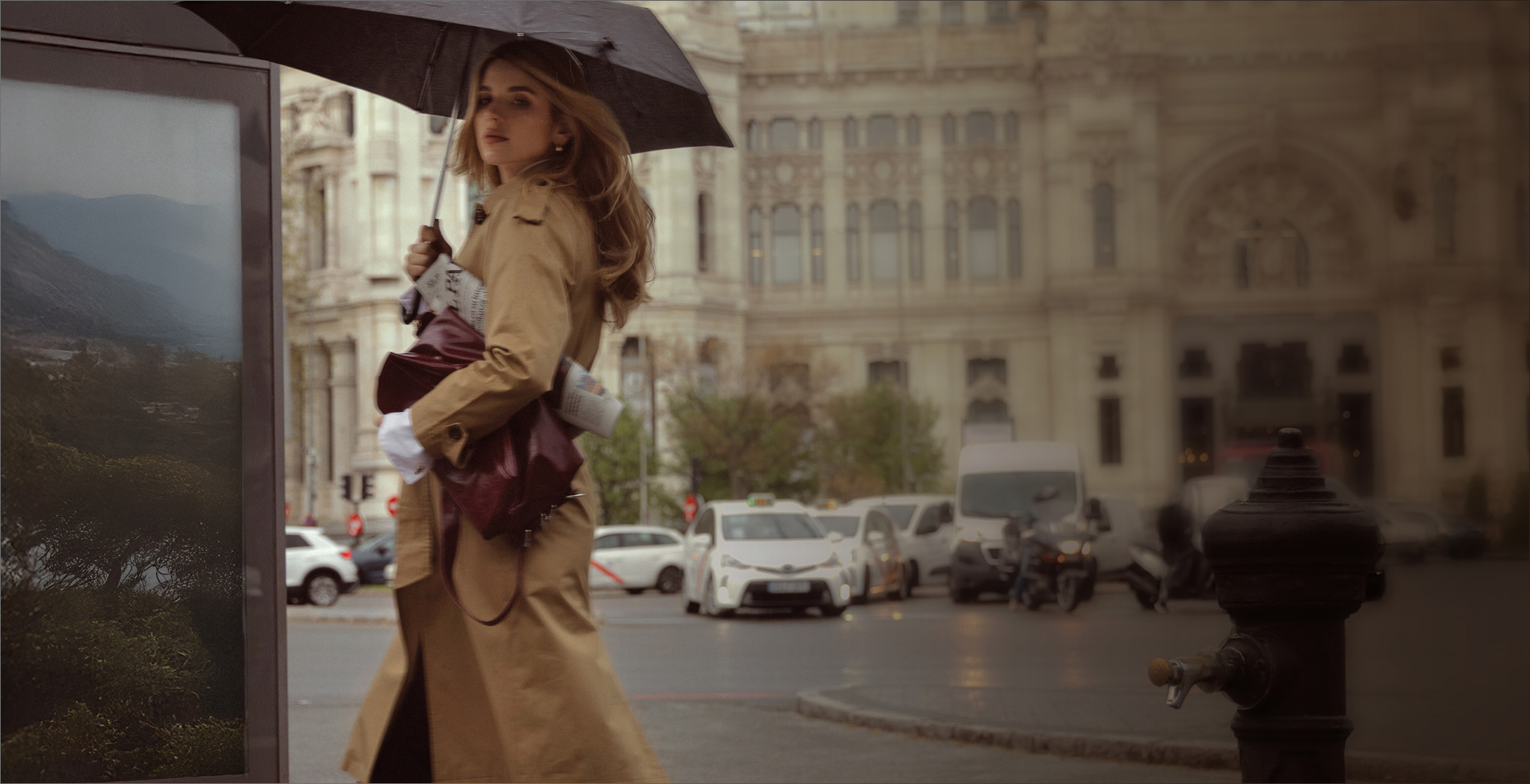 Foto de 3 modelos vistiendo: un gaban beige sosteniendo un bolso y sombrilla.